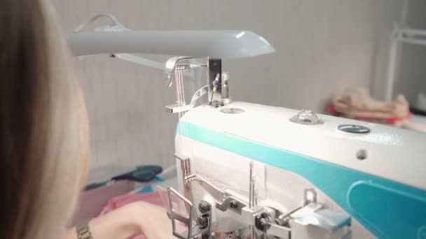 Tailor woman sewing pink clothes on electric machine — Stock Video