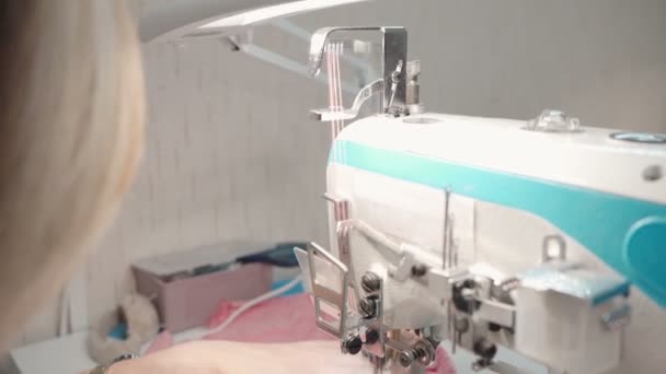 Портной шьет розовую одежду на фабрике — стоковое видео