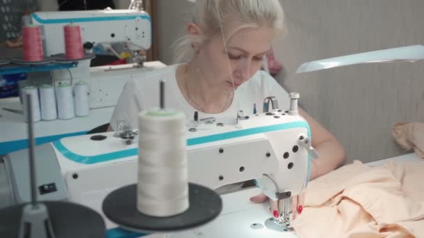 Video de una joven mujer cosiendo orden en la máquina eléctrica en el taller — Vídeo de stock