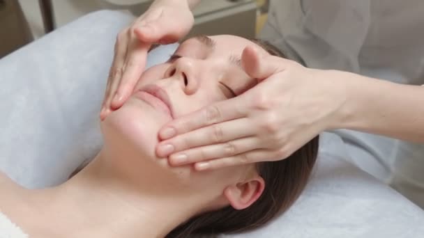 Vídeo de mulher morena recebe um curso de massagem facial — Vídeo de Stock