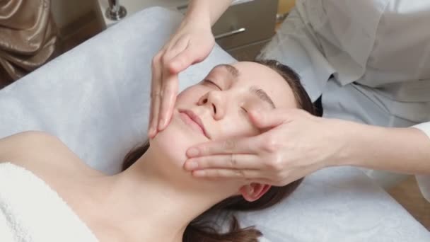 Vídeo de mulher morena recebe uma massagem facial — Vídeo de Stock