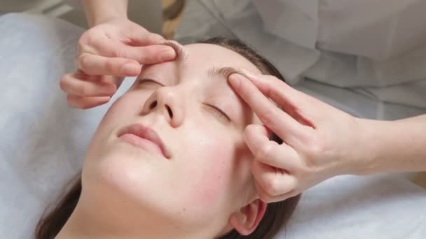 Зйомки брюнетки отримує курс масажу обличчя — стокове відео