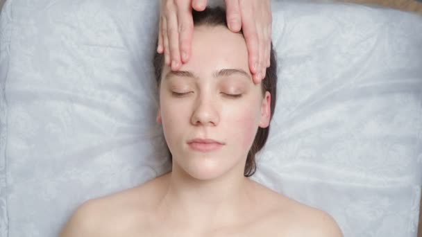 Video de mujer joven recibe un curso de masaje facial — Vídeos de Stock