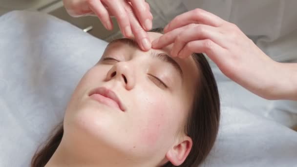 Tir de femme brune obtient un cours de massage facial dans le salon — Video