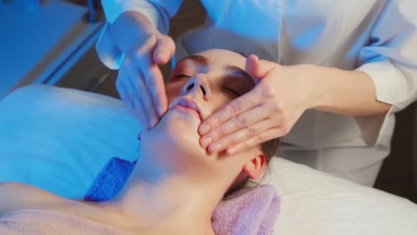 Video av liggande kvinna får en ansiktsmassage på kliniken — Stockvideo