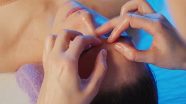 Tiro di giovane ragazza ottiene un massaggio facciale in clinica — Video Stock