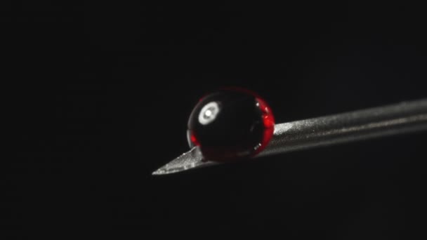 Video of needle with drop of red liquid — Stockvideo