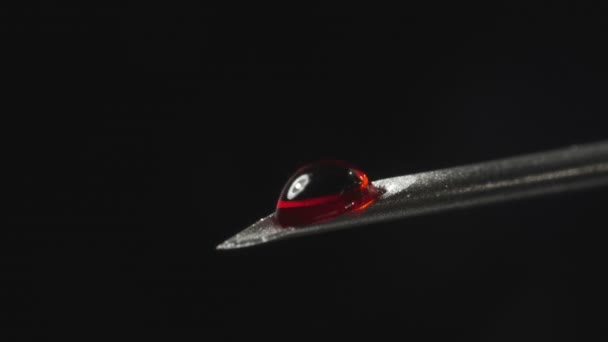 Syringe needle with drop of red liquid — Stockvideo