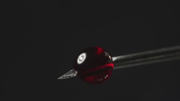 Vidéo de l'aiguille de la seringue avec des gouttes de liquide rouge — Video
