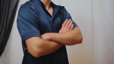 Tüylü ve kollarını kavuşturmuş genç bir adamın portresi.