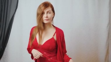 Kızıl saçlı güzel kızın kırmızı ipek pijamalı videosu.