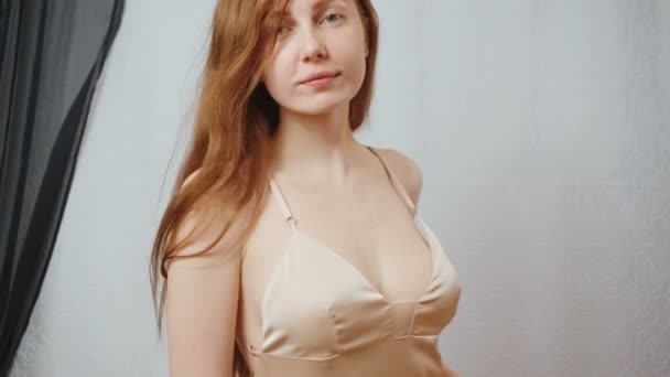 Video of redhead young girl in beige silk nightdress — ストック動画
