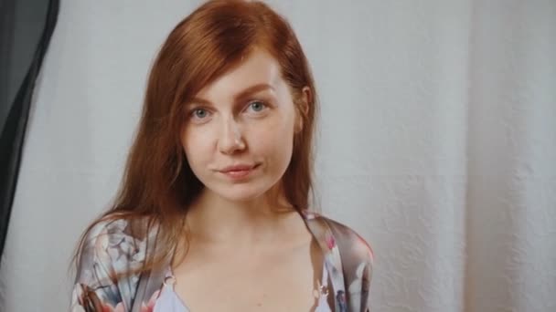 Vörös hajú nő szürke peignoir otthon belső — Stock videók