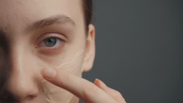 Jong meisje zet een concealer op haar gezicht — Stockvideo