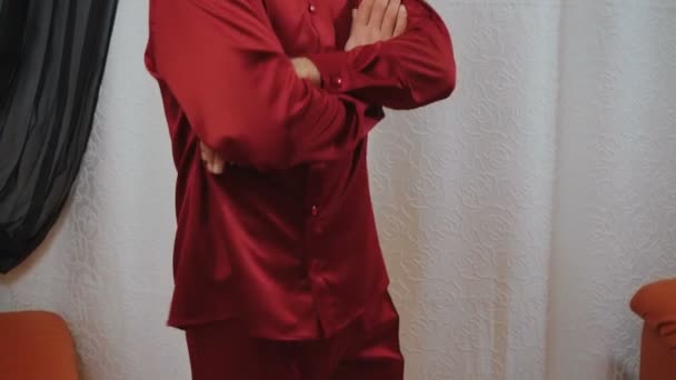 Kırmızı ipek pijamalı ve kolları bağlı bir adamın videosu. — Stok video