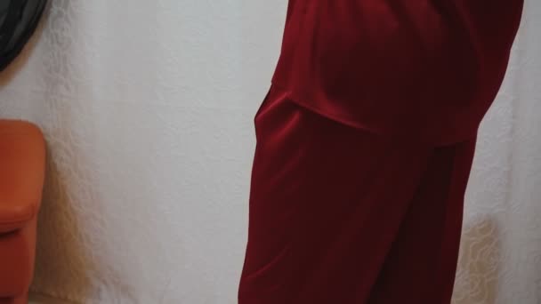 Видео позирующего человека в красной шелковой пижаме со скрещенными руками — стоковое видео