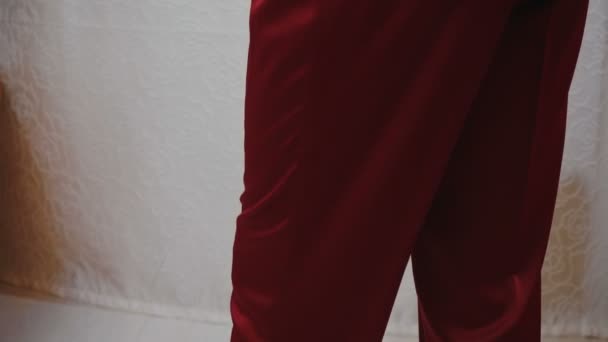 Мужчина в красной шелковой пижаме со скрещенными руками — стоковое видео