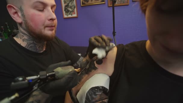 Tiro de homem fazendo tatuagem escura de cobra em estúdio — Vídeo de Stock