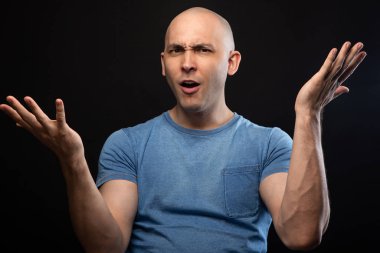 Photo of bald man in blue tee shirt with open hands