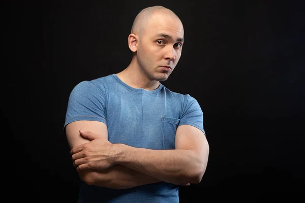 Foto eines jungen Mannes mit Glatze im blauen T-Shirt mit verschränkten Armen — Stockfoto