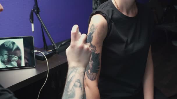 Стрельба мастера татуировок, делающего дезинфекцию — стоковое видео