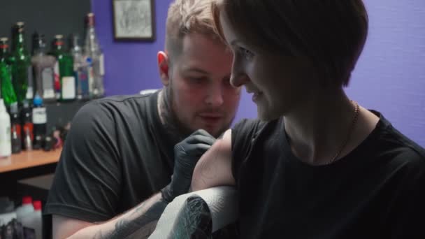 Tattooer getting tattoo of snake in salon — Stockvideo