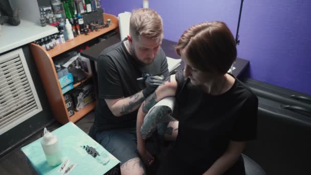 Young master getting tattoo of snake in salon, top view — Stok video