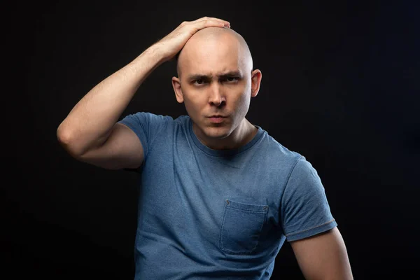 Retrato de homem careca em camiseta azul com a mão na cabeça — Fotografia de Stock