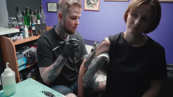 Кадры, на которых молодой хозяин делает татуировку змеи — стоковое видео