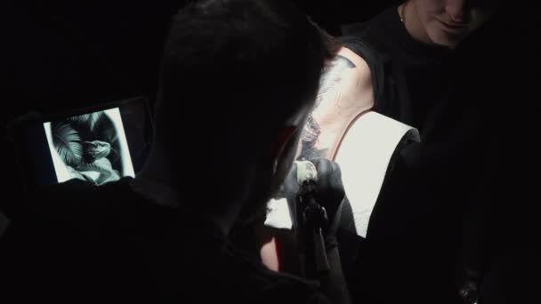 Bilder på man som gör svart tatuering av orm för kvinna i studio — Stockvideo