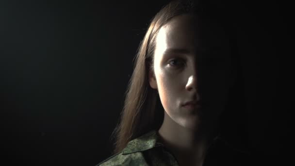 Video of young woman in military uniform in shadow — Stok video