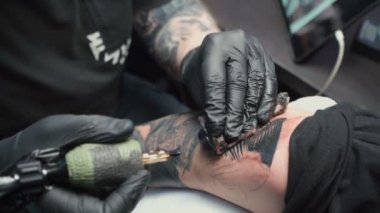 Shooting of professional getting tattoo of snake in salon