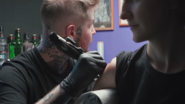 Footage of young tattooer getting tattoo of snake in salon — ストック動画