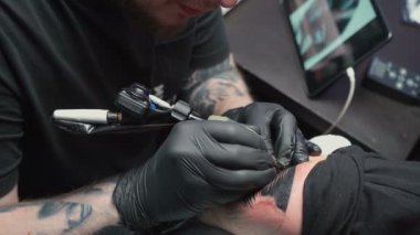 Professional getting tattoo of snake in studio