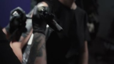 Footage of man doing tattoo of snake for woman