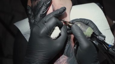 Video of man doing black tattoo of snake