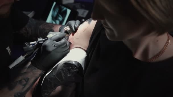 Видео, где мужчина делает татуировку для женщины в студии — стоковое видео