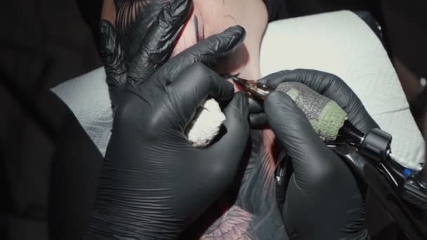 Видео, где человек делает черную татуировку змеи — стоковое видео