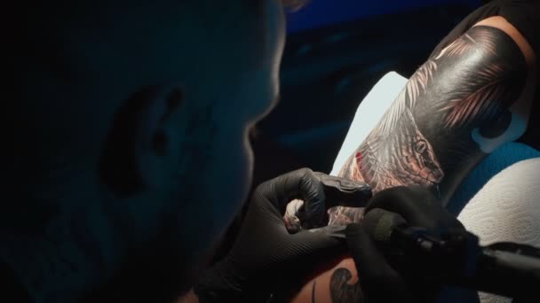 Close up video of doing black tattoo of snake for woman in studio — Stockvideo