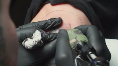 Man tattooist getting tattoo of snake for woman