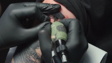 Video of man tattooist getting tattoo of snake, closeup