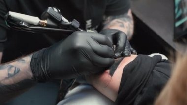 Footage of professional getting tattoo of snake in studio
