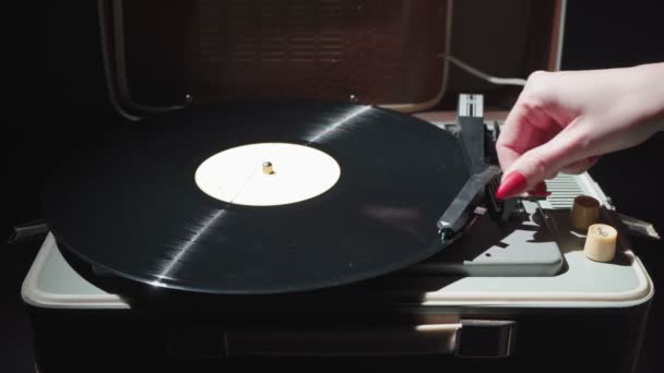 Vidéo de fille avec des ongles rouges allumant le gramophone vintage — Video