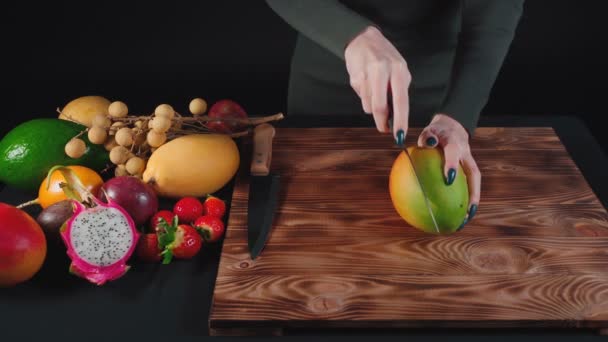 Video of woman cuts mango on wooden board — 图库视频影像