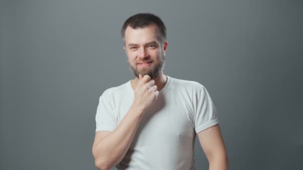 음모를 꾸미는 젊은 남자가 턱수염을 치는 모습 — 비디오