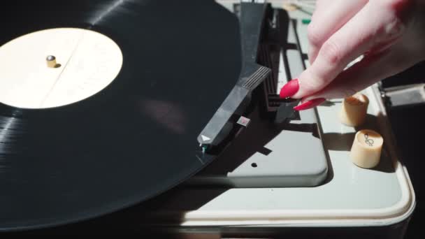 Filmación de una mujer con uñas rojas encendiendo el gramófono retro — Vídeo de stock