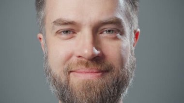 Sakallı, gülümseyen bir adamın aşırı yakın çekim videosu.