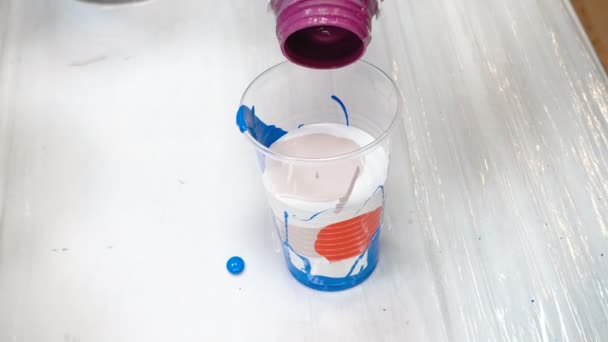 Mélange de peintures acryliques dans une tasse en plastique 