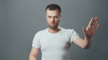 Sakallı genç adam hiç hareket göstermiyor.