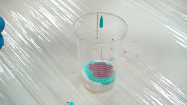 Tournage de peintures acryliques dans une tasse en plastique 